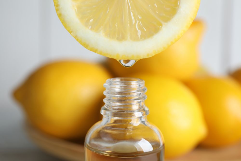 Citronsaft som droppar ner i en flaska – citrusoljor kan vara fototoxiska.