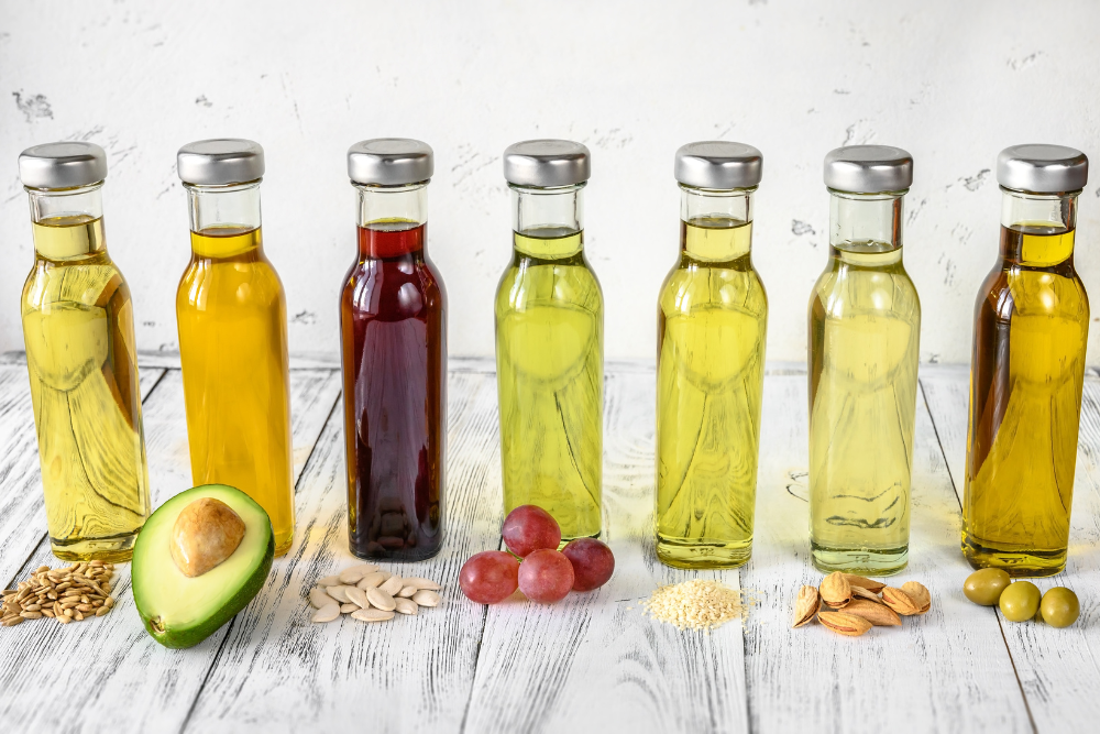 Olika sorters naturliga bäraroljor på flaskor – avokado, druvkärnor, oliver och andra råvaror