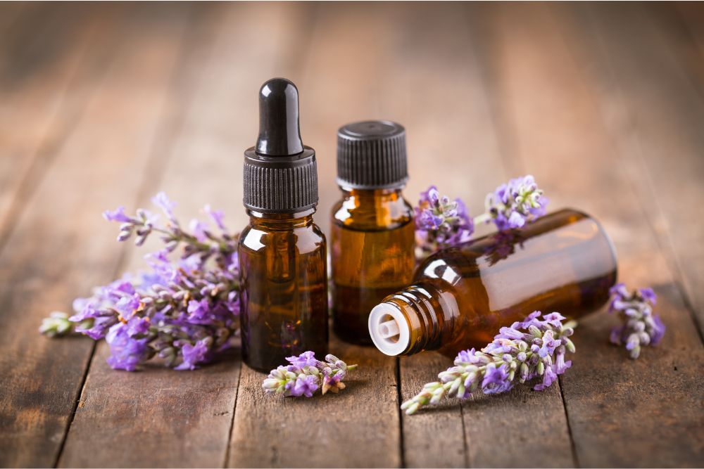 Flaskor med eterisk lavendelolja och lavendelblommor på ett träbord – naturlig kosmetika.