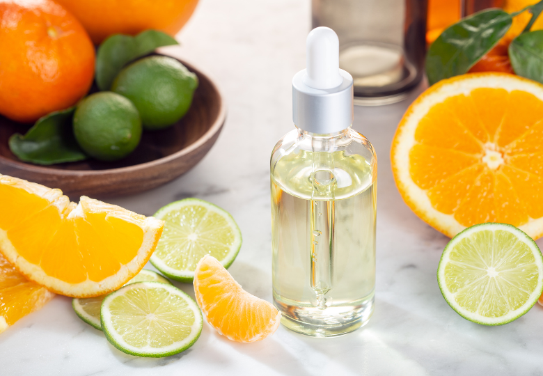 Flaska med eterisk citronolja bland färska citrusskivor – ett naturligt hjälpmedel för städning utan kemi.